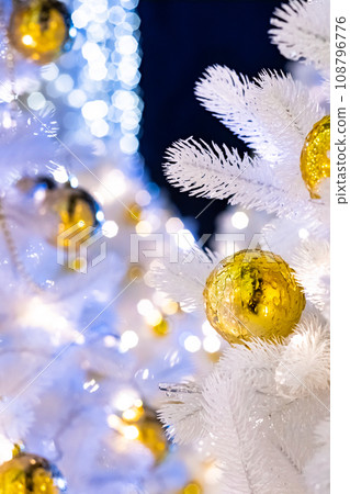 Selective focus on golden iced Christmas ball on white artificial fir branches. Selective focus on golden iced Christmas ball on white artificial fir branches. 108796776