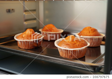 Electric mini oven and baked hot muffins close up 108797675