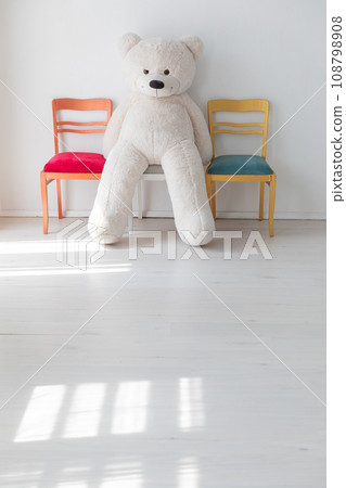 Toy polar teddy bear sitting on chair in room interior Toy polar teddy bear sitting on chair in room interior 108798908