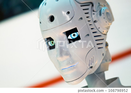 Closeup of white illuminated human robot looking away against blurred background 108798952