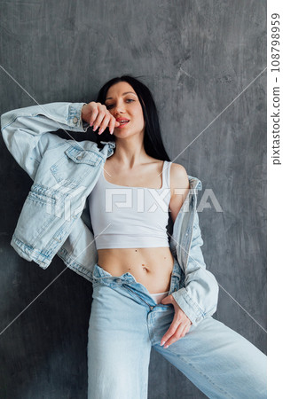 Portrait of a beautiful brunette woman in denim clothes Portrait of a beautiful brunette woman in denim clothes 108798959