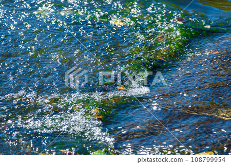 flow of water and spray from a stone 108799954