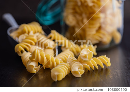 Uncooked fusilli pasta. Uncooked italian pasta in scoop. Uncooked fusilli pasta. Uncooked italian pasta in scoop. 108800590