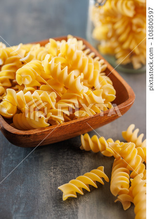 Uncooked fusilli pasta. Uncooked italian pasta on kitchen table. 108800597
