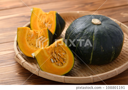 Pumpkin on a colander, wood grain background Pumpkin on a colander, wood grain background 108801191