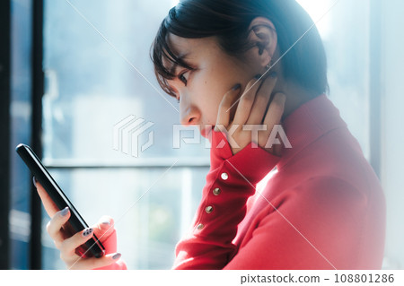 Smartphone: A woman using a mobile phone Smartphone: A woman using a mobile phone 108801286