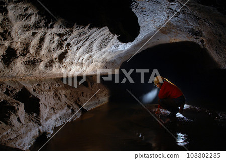 Cave explorer, spelunker, archeologist studying underground passage 108802285