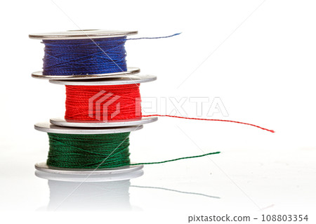 spools of thread in blue, red, green colors on a white background spools of thread in blue, red, green colors on a white background 108803354