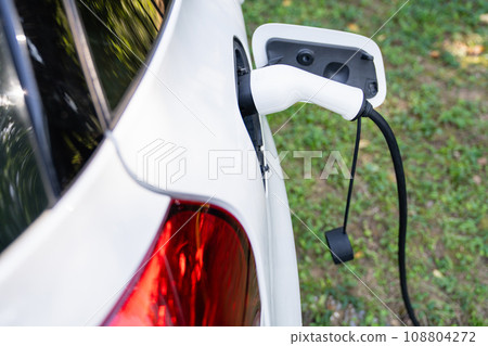 Close up of electric car inlet with a connected charging cable 108804272