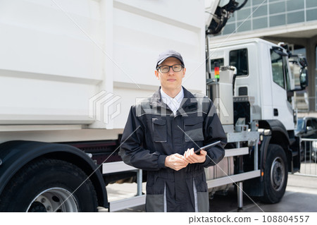 Manager with a digital tablet next to garbage truck Manager with a digital tablet next to garbage truck 108804557