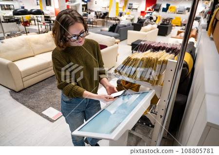 Woman with phone uses self-service kiosk in the shopping mall 108805781