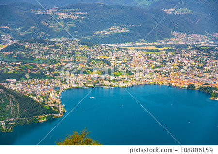 Lugano Lake, Italian: Lago di Lugano, and Lugano city. Lookout from Balcony of Italy on Mount Sighignola. Italy and Switzerland Lugano Lake, Italian: Lago di Lugano, and Lugano city. Lookout from Balcony of Italy on Mount Sighignola. Italy and Switzerland 108806159