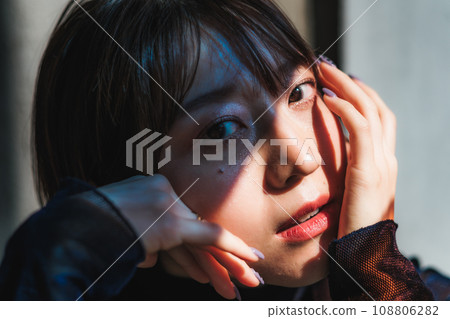 Short-haired woman sitting by the window 108806282