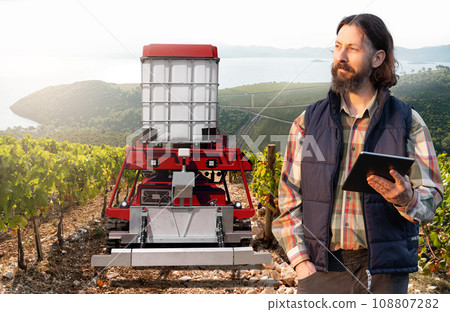 Autonomous robot sprayer works in a vineyard. Autonomous robot sprayer works in a vineyard. 108807282