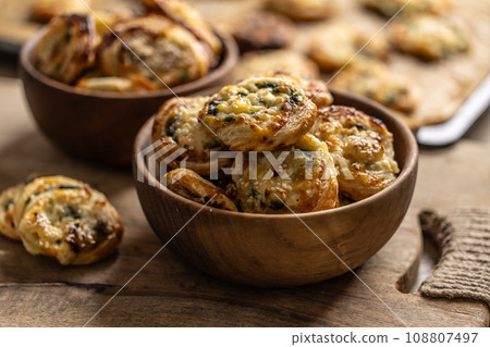Mini pizza rolls stuffed with various ingredients, prosciutto bacon spinach basil mozzarella or parmesan cheese in wooden bowl Mini pizza rolls stuffed with various ingredients, prosciutto bacon spinach basil mozzarella or parmesan cheese in wooden bowl 108807497