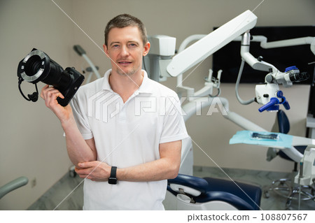 Dentist with photo camera in dental office 108807567
