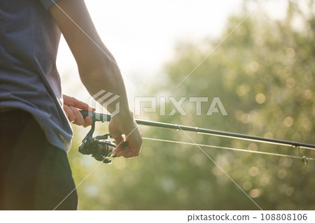 Close-up of hands with a fishing rod 108808106