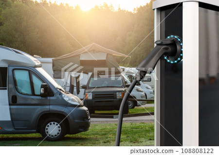 Close-up of a charging station for electric car against the backdrop of a campsite. Close-up of a charging station for electric car against the backdrop of a campsite. 108808122