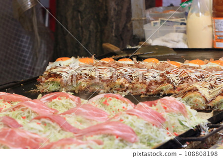 Okonomiyaki from food stalls on festival days Okonomiyaki with plenty of eggs and vegetables Okonomiyaki from food stalls on festival days Okonomiyaki with plenty of eggs and vegetables 108808198