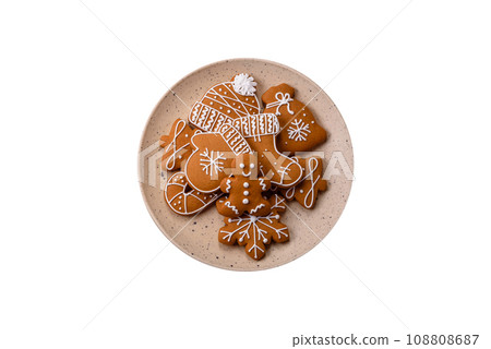 Beautiful Christmas gingerbread cookies of different colors on a ceramic plate Beautiful Christmas gingerbread cookies of different colors on a ceramic plate 108808687