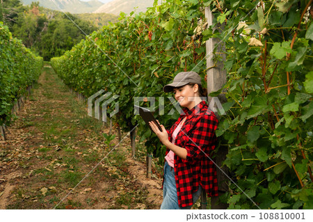 A woman farmer examines the vineyard 108810001