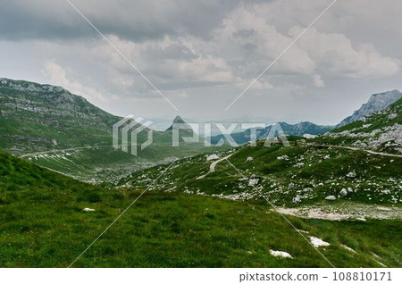 The road along the alpine meadows. High mountains. The road along the alpine meadows. High mountains. 108810171