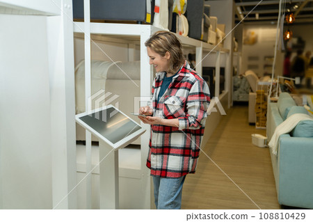 Woman uses the self-service kiosk Woman uses the self-service kiosk 108810429