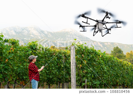Woman farmer controls drone sprayer 108810456