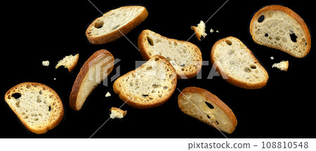 Falling bruschetta crackers, round bread croutons isolated on black background 108810548