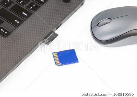 sd memory card for recording electronic data near a laptop on a white background sd memory card for recording electronic data near a laptop on a white background 108810590