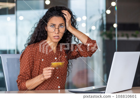 Portrait of unhappy and cheated business woman at workplace, female employee with bank credit card and laptop looking excited and nervous at camera, received fund transfer rejection, password error. 108810601