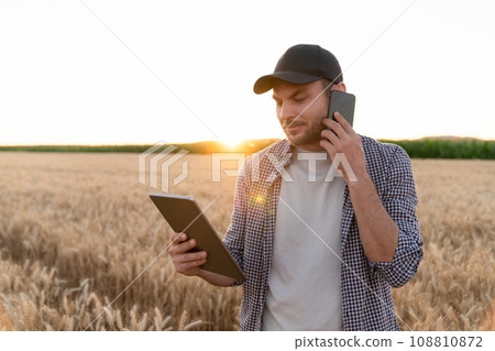 Bearded farmer with mobile phone and digital tablet Bearded farmer with mobile phone and digital tablet 108810872