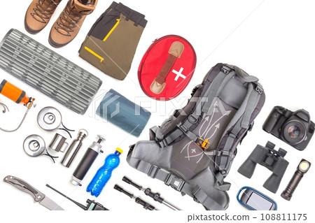 Set of tourist trekking items on white background. Top view of accessories for travel Set of tourist trekking items on white background. Top view of accessories for travel 108811175