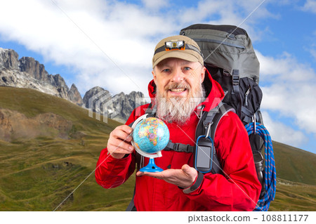 bearded tourist in a red jacket holds a model of the world globe in his hands bearded tourist in a red jacket holds a model of the world globe in his hands 108811177