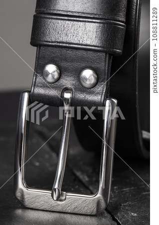 Part of a black crocodile leather belt. Expensive leather goods. 108811289