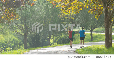 Two men running in the green park Two men running in the green park 108811573