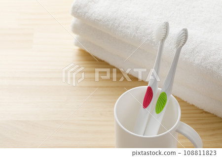 White toothbrush, cup and towel toothpaste image 108811823