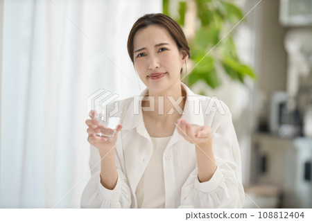 woman taking medicine in the living room 108812404