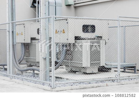 Electricity transformer high voltage Three phase electric power with safety area fence protection zone in industry building. 108812582