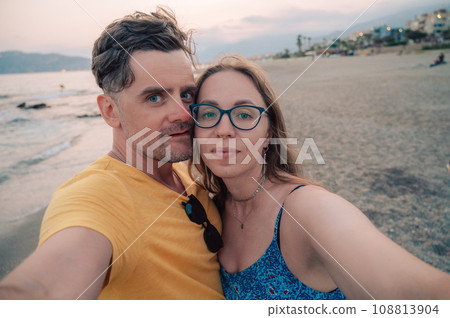Happy couple taking a photo on a beach 108813904
