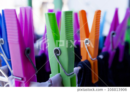 Clothespins holding clothes on clothesline. Various colors. 108813906