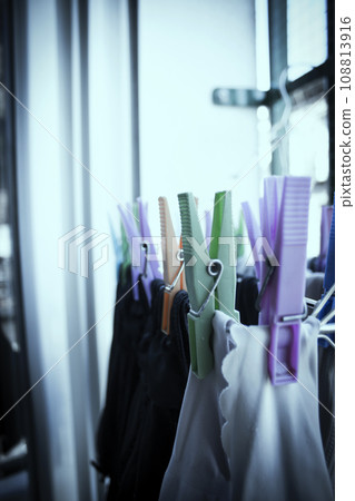 Clothespins holding clothes on clothesline. Various colors. 108813916