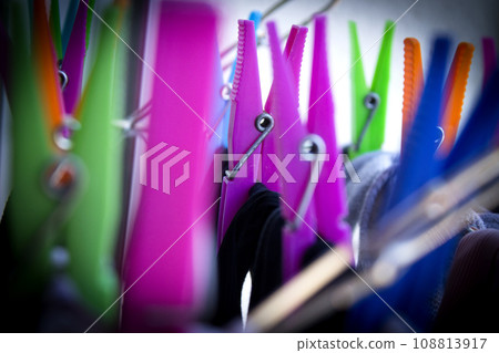 Clothespins holding clothes on clothesline. Various colors. 108813917