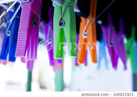 Clothespins holding clothes on clothesline. Various colors. 108813921