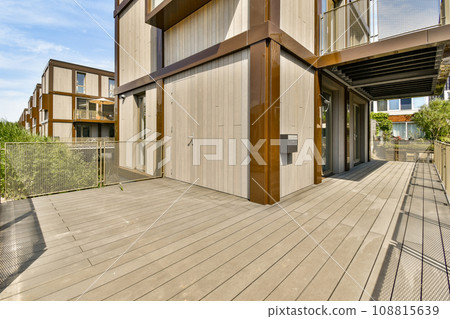 an outside area with wood flooring and metal railings on the side of a house that has been painted white an outside area with wood flooring and metal railings on the side of a house that has been painted white 108815639