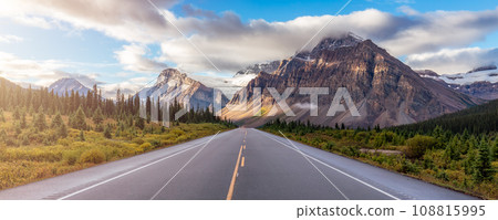 Scenic Road with green trees and Alpine Mountain Peaks in Canadian Nature Landscape. Scenic Road with green trees and Alpine Mountain Peaks in Canadian Nature Landscape. 108815995