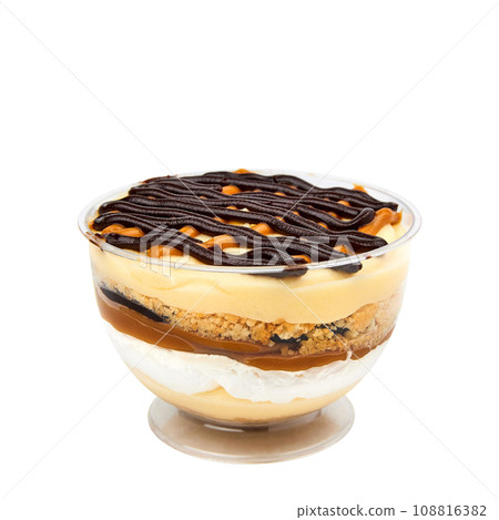 Layered banana dessert made of crispy cookies, custard, banana, salted caramel, chocolate and whipped cream isolated on white Layered banana dessert made of crispy cookies, custard, banana, salted caramel, chocolate and whipped cream isolated on white 108816382