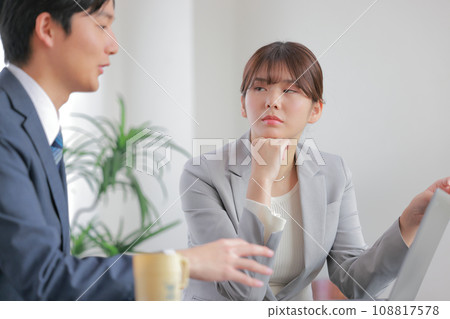 A businessman who talks about his theory for a long time and a businesswoman with a disgusted expression 1 A businessman who talks about his theory for a long time and a businesswoman with a disgusted expression 1 108817578