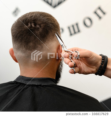 Haircut alignment of the contour of the head with scissors. Short haircut in the barbershop. Haircut alignment of the contour of the head with scissors. Short haircut in the barbershop. 108817629