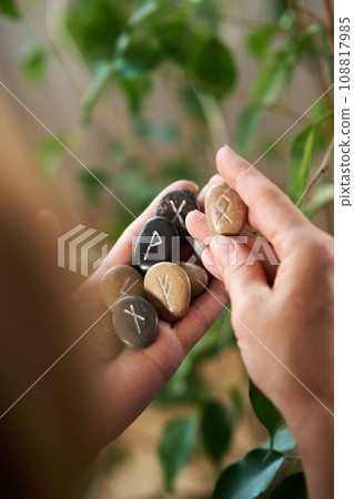 stone runes in a woman's hand stone runes in a woman's hand 108817985